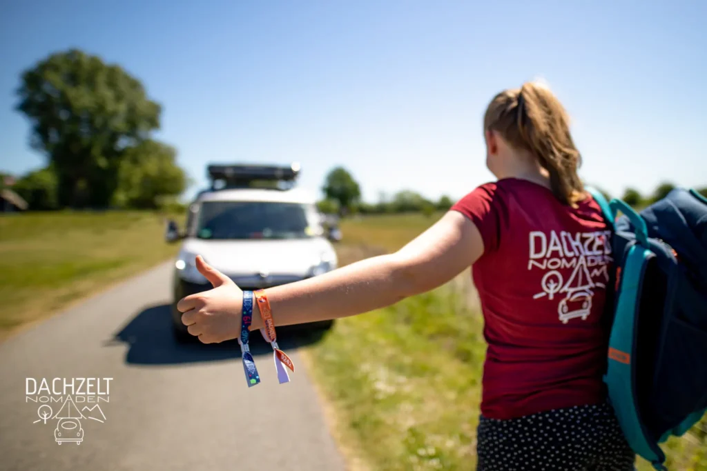 weisses Auto mit Dachzelt und eine Frau