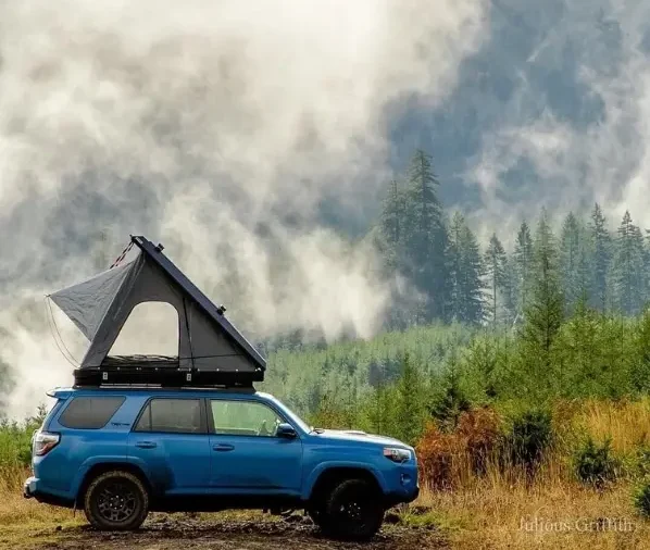 Dreieck Hartschalendachzelt auf einem blauen auto im Wald