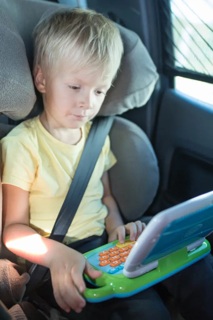 kind im auto mit kinderlaptop