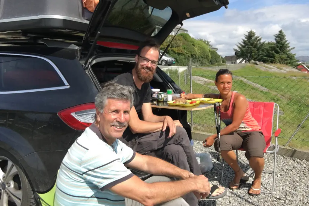 zwei männer und eine frau beim campen campingstühle auto heckklappe