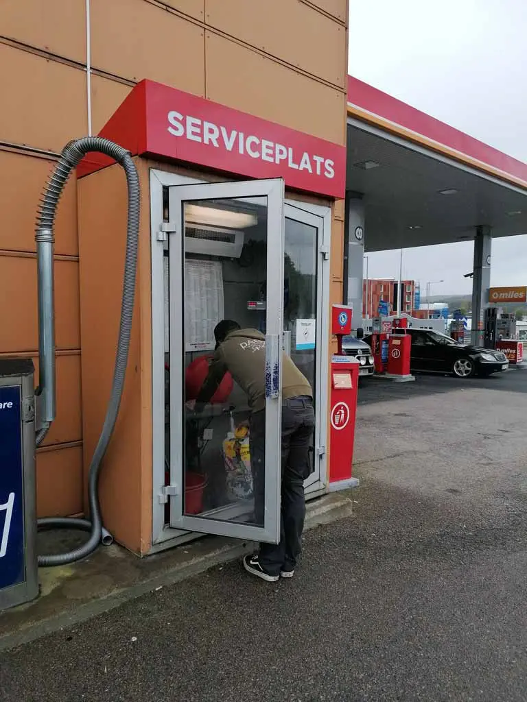 Mann an Wassernachfüll-Station in Schweden