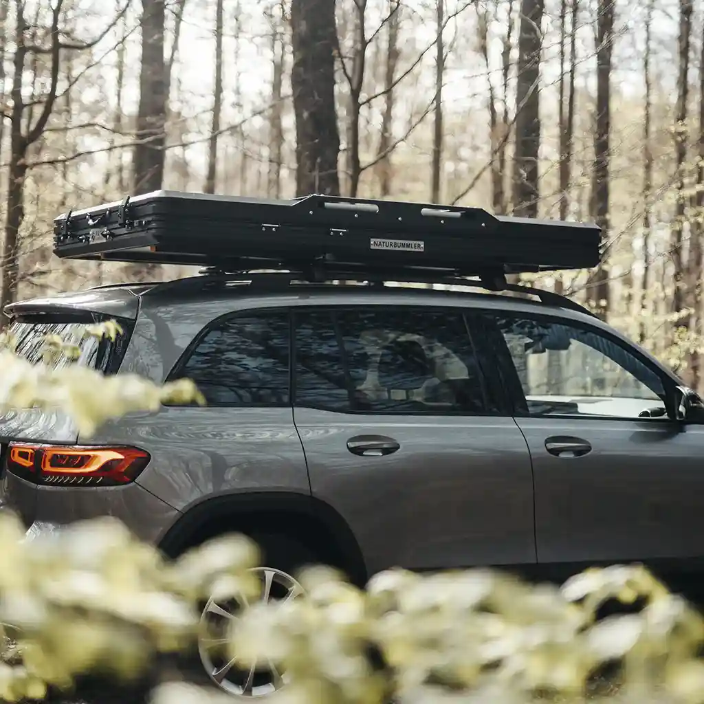 naturbummler dachzelt geschlossen auf dem auto montiert wald