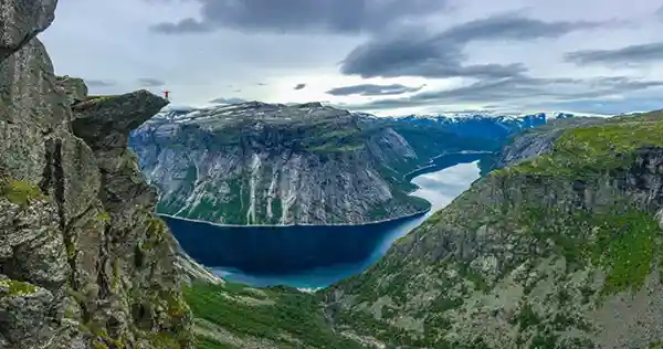 fjord berg bewölkter himmel begrünte felsen Trolltunga Norwegen