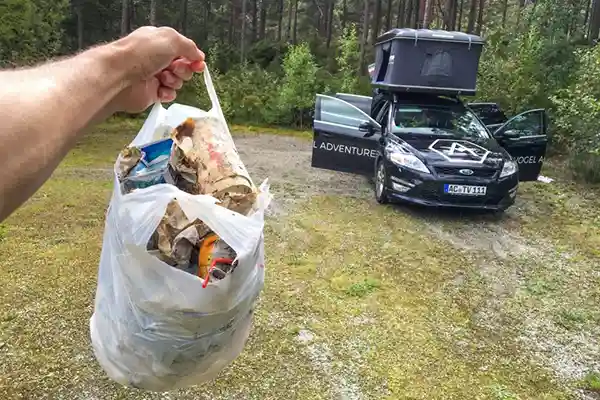 Abfall in Beutel Auto mit Dachzelt Müllzange