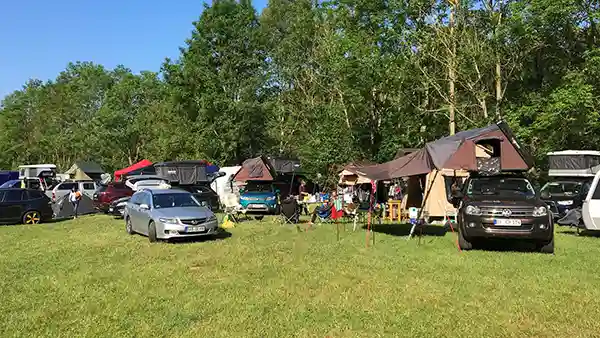 DACHZELT CAMP Frankenroda Autos mit Dachzelten Wald im Hintergrund blauer Himmel grüne Wiese