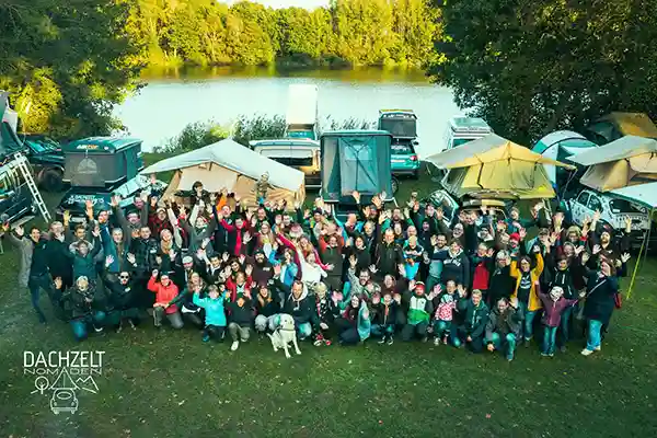 Luftaufnahme von menschen in der natur fluss im hintergrund wald und autos mit dachzelten