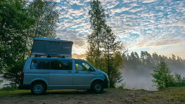 maggiolina hartschalen dachzelt viereck auf einem auto offen sonnenuntergang bäume blauer wolkiger himmel