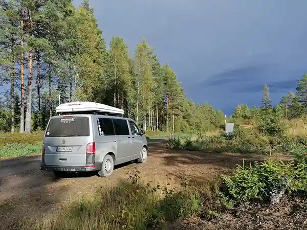 Autohome Maggiolina auf grauem Auto wald wiese berge im hintergrund