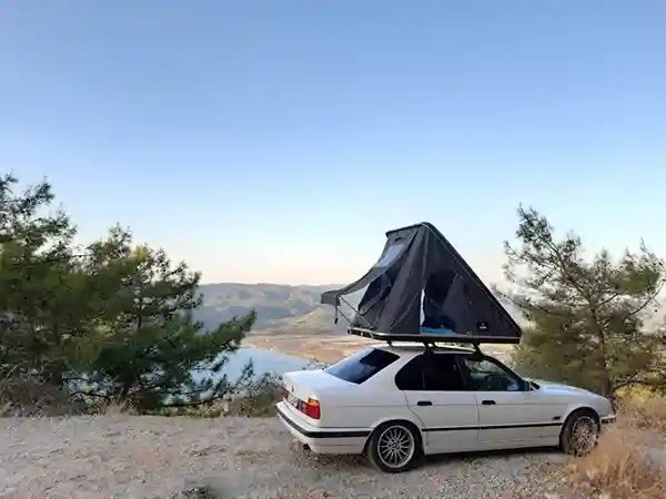 dachzelt reise türkei schwarzes dachzelt auf weissem auto blauer himmel büsche