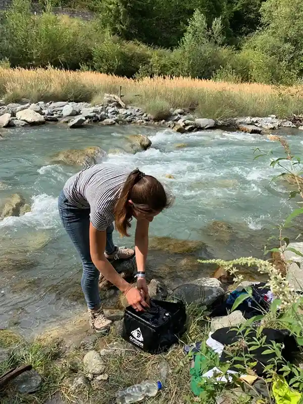 frau wäscht wäsche am fluss