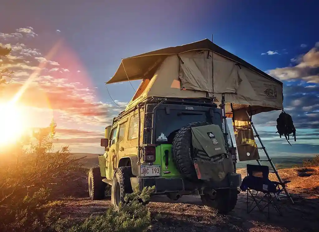 klappdachzelt auf einem geländewagen im sonnenuntergang