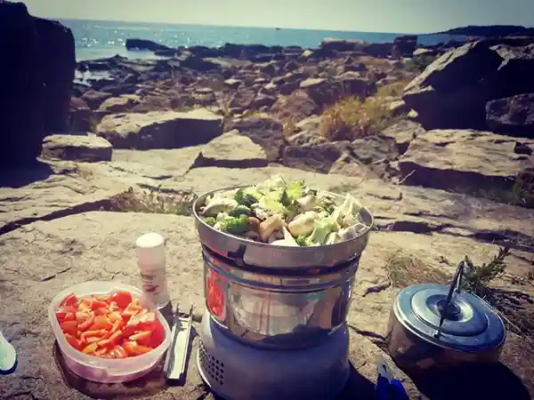 Spirituskocher am meer, gemüse kochen unterwegs camping outdoorküche