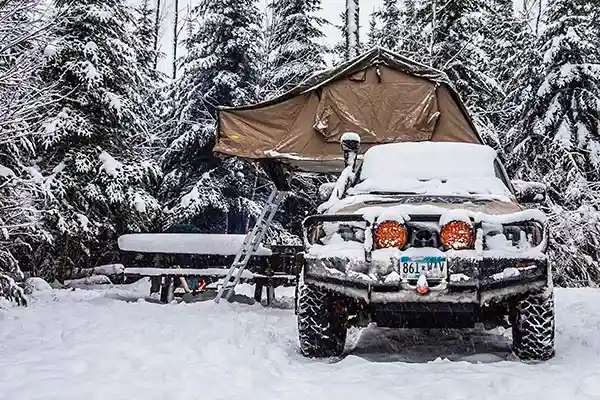 klappdachzelt auf geländewagen tannenwald schnee winterlandschaft