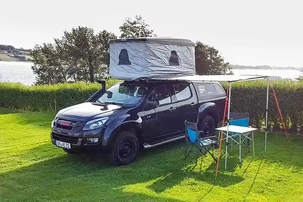 Viereck Hartschalendachzelt mit Thermohaube auf einem dunkelblauen auto wiese