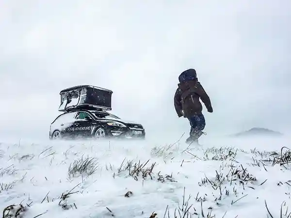 wintersturm schnee dachzelt offen mann in winterkleidung