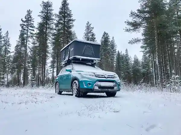 Suzuki mit Dachzelt in Winterlandschaft, Schnee Waldrand