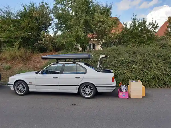 weisser bmw mit dachzelt und gepäck geparkt