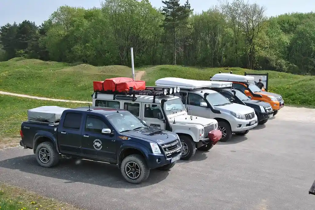 dachzelt reise bourgogne franche comte geparkte Autos mit geschlossenen dachzelten wald und wiese im hintergrund