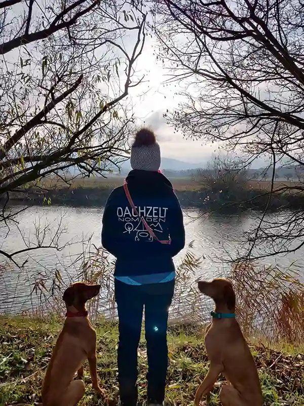 Frau mit zwei Hunden am See, herbstliches Wetter