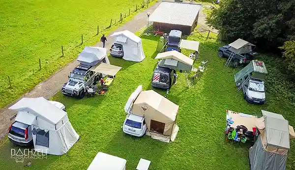 klappdachzelte auf autos montiert auf einer grünen wiese