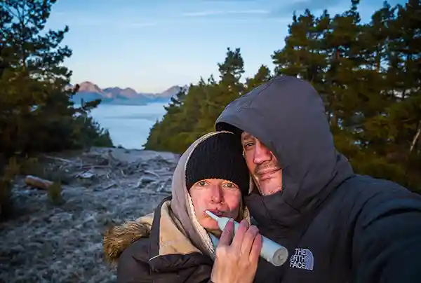 Mann und Frau Zähneputzen see wald fels